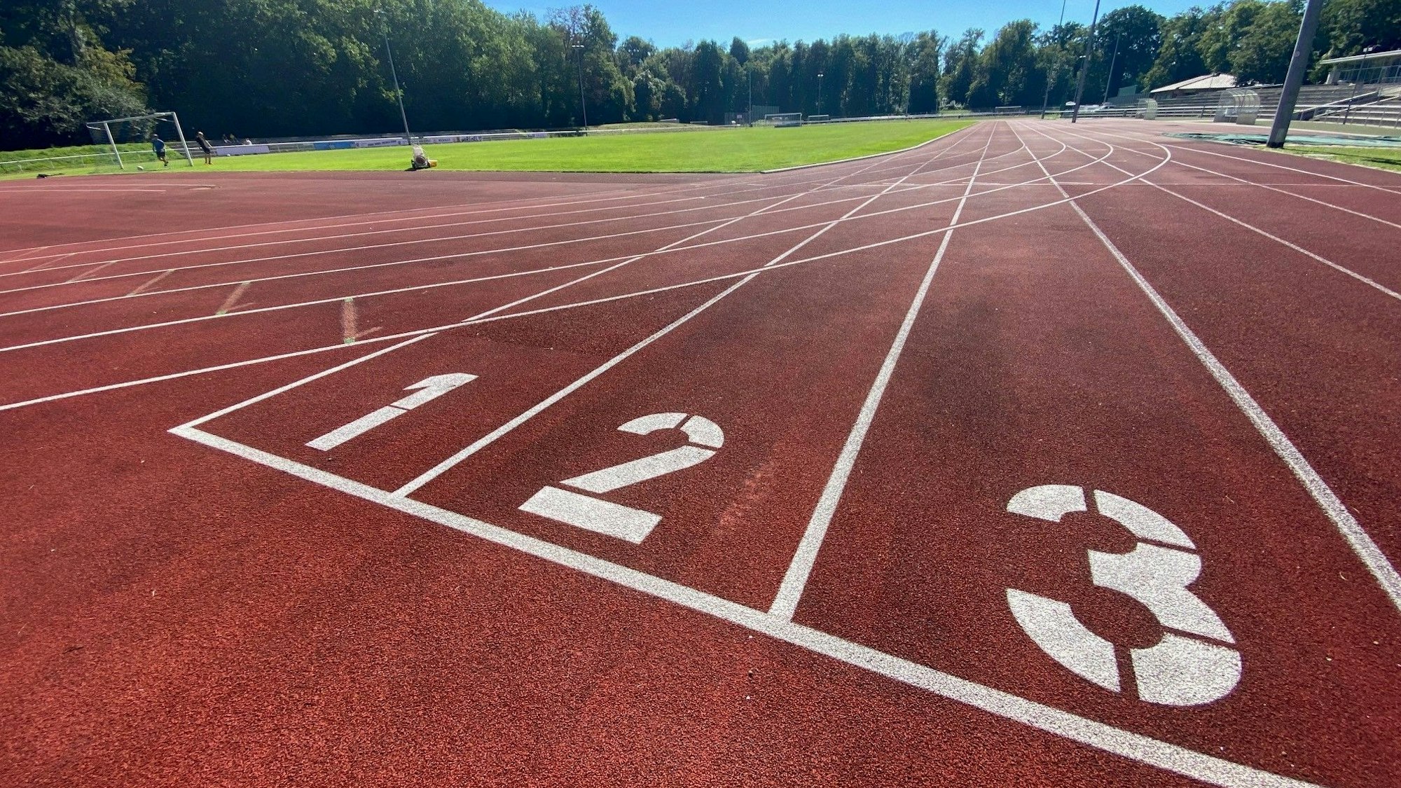 Zu sehen ist die rote Laufbahn des Schlossparkstadions mit den nummerierten Bahnen.