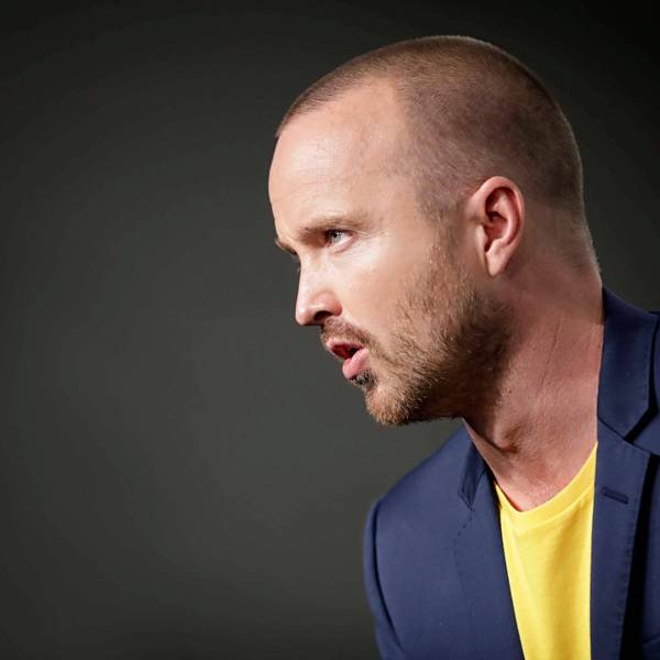 US-Schauspieler Aaron Paul ist auf einer Bühne im Anzug zu sehen.