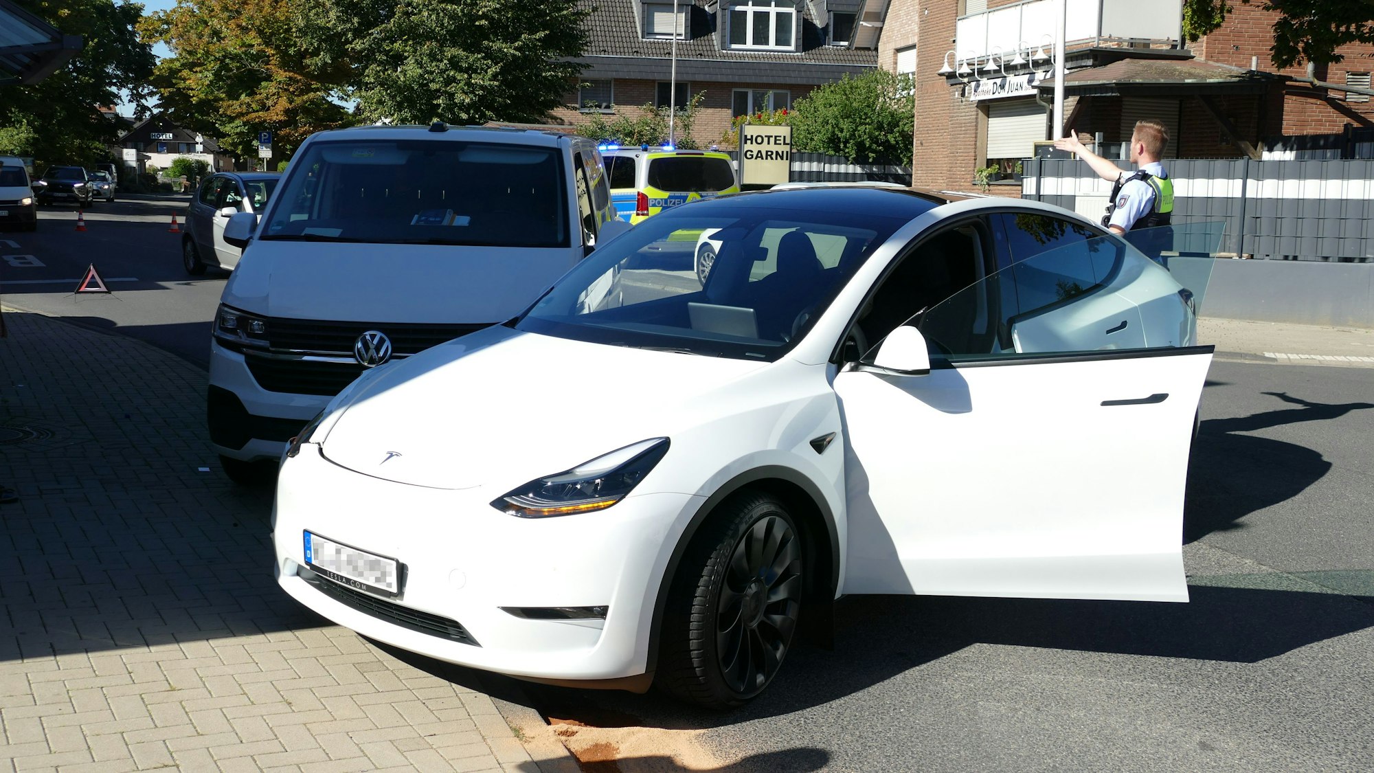 Ein beschädigter Tesla steht an einer Unfallstelle.