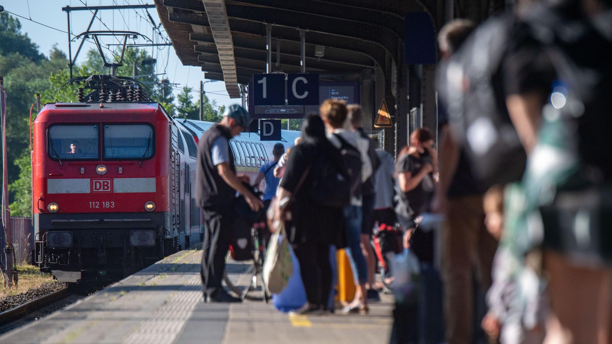 Fahrgäste warten im Bahnhof auf eine Regionalbahn.