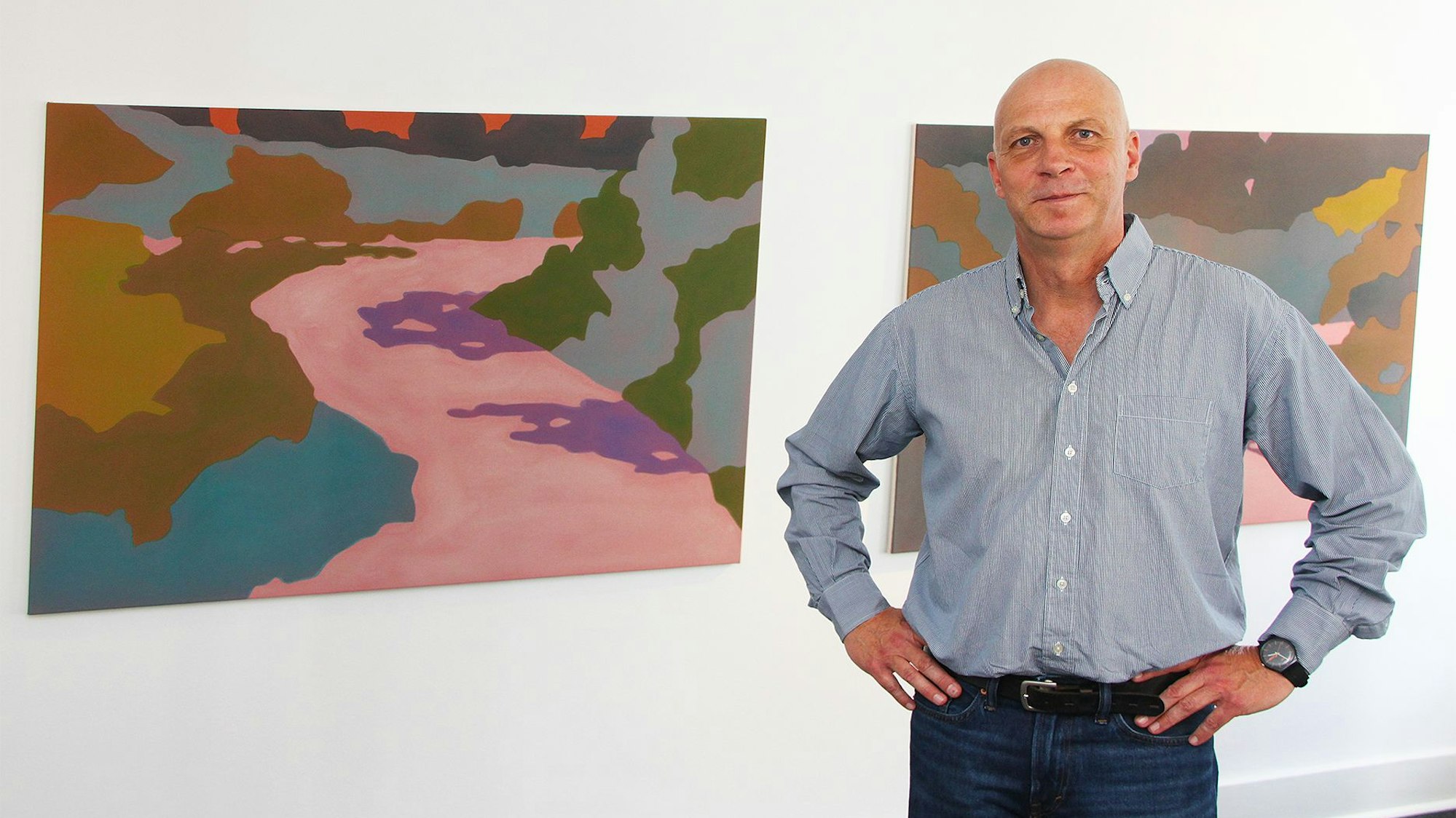 Der Künstler Benjamin Nachtwey steht vor zweien seiner Werke.