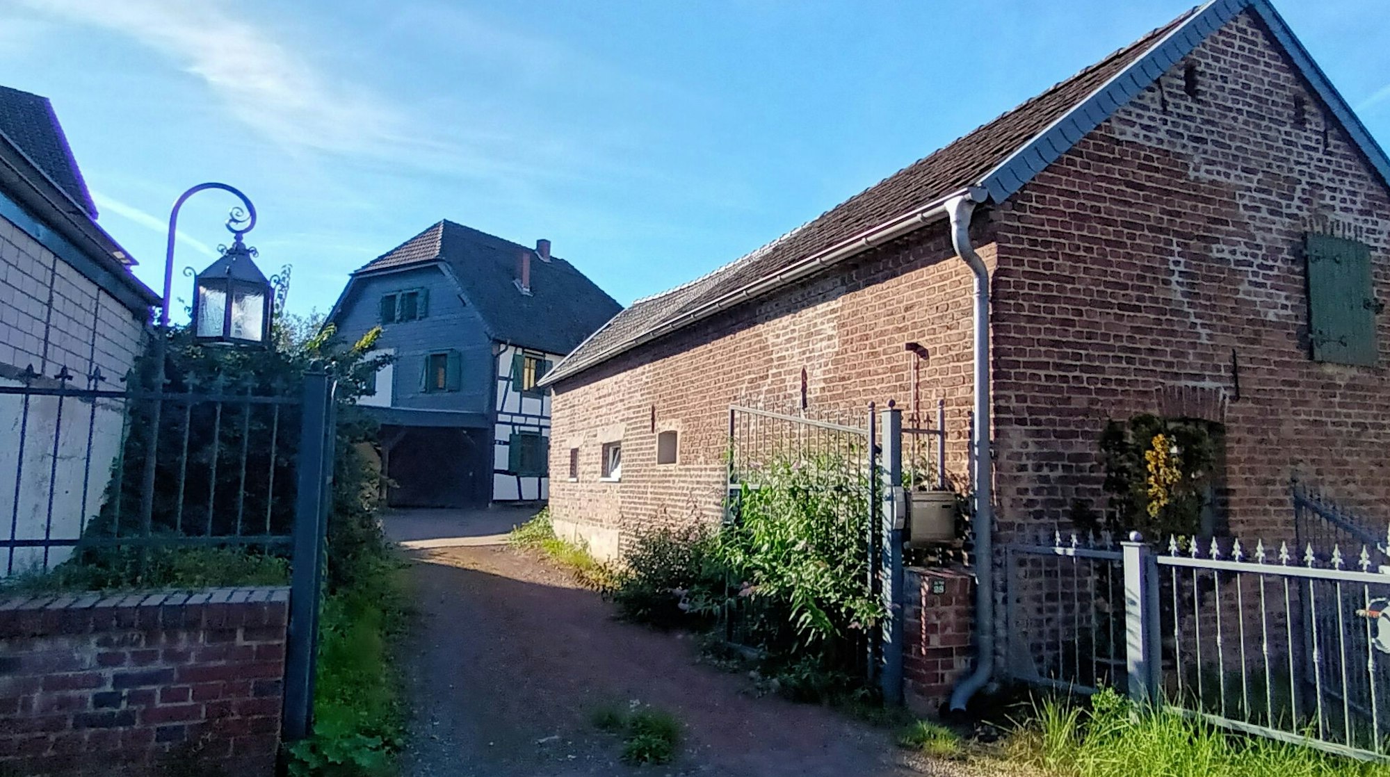 Eine Einfahrt führt zu einem Fachwerkwohnhaus