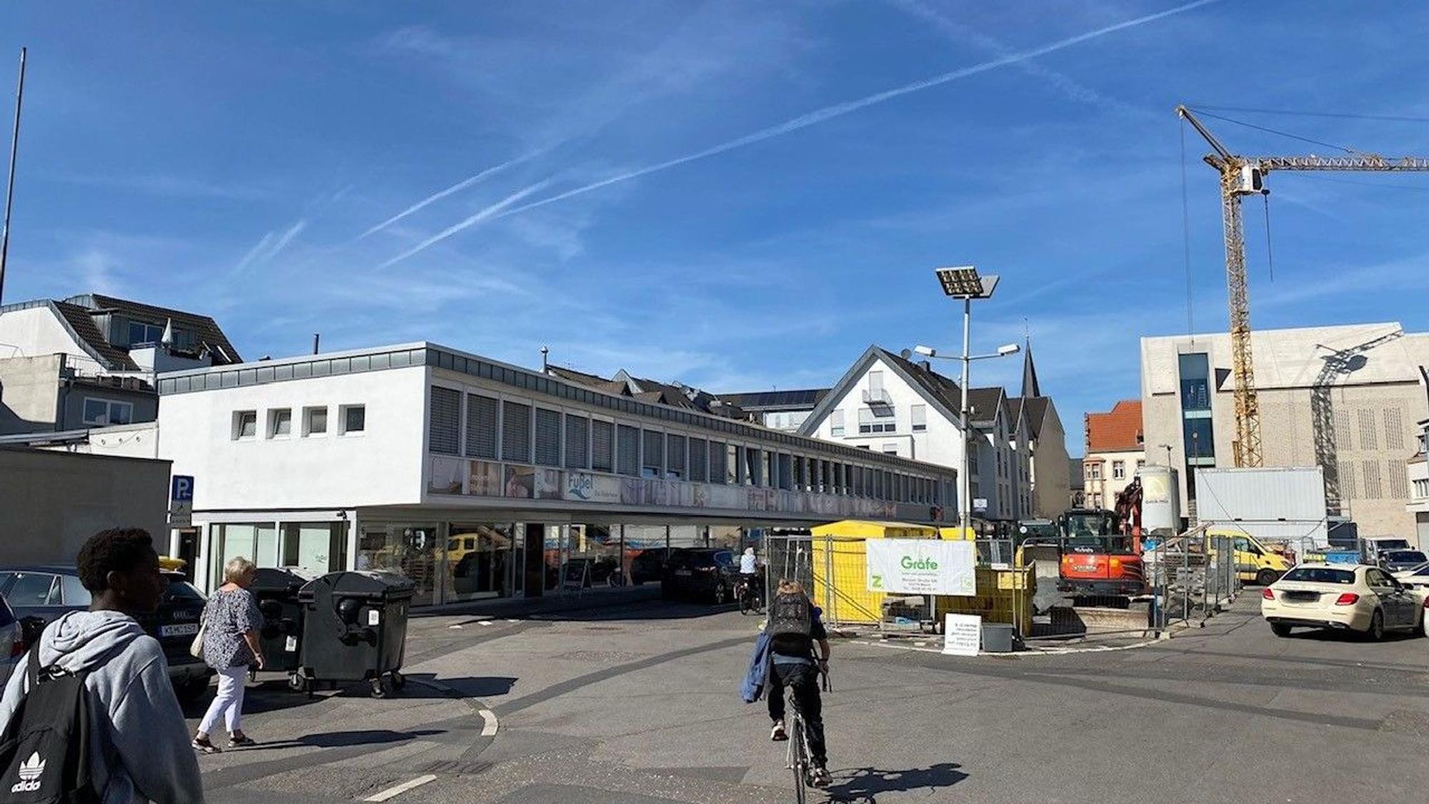 Zu sehen ist der Platz, auf dem Baumaschinen und -material lagert. Im Hintergrund ist der Rathausneubau zu erkennen.