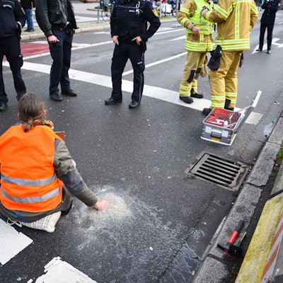 ARCHIV - 06.01.2023, Baden-Württemberg, Mannheim: Ein Aktivist der Gruppierung Letzte Generation sitzt mit einer angeklebten Hand auf der Straße. (zu dpa «Weitere Entwicklung nach dem umstrittenen Vorgehen der Polizei in Mannheim gegen Klimaaktivisten») Foto: René Priebe/dpa +++ dpa-Bildfunk +++