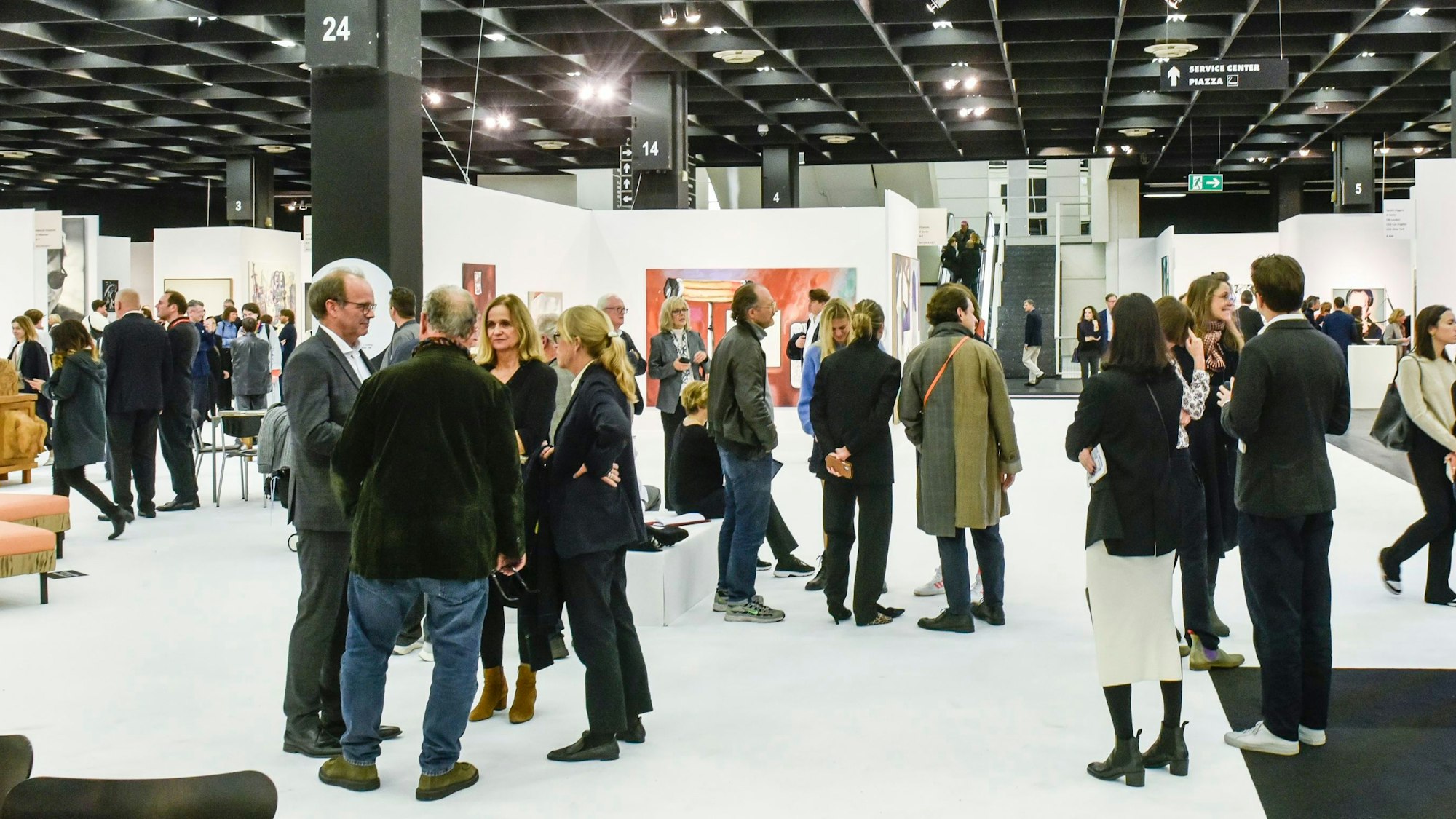 Menschen unterhalten sich in der Kölner Messehalle.
