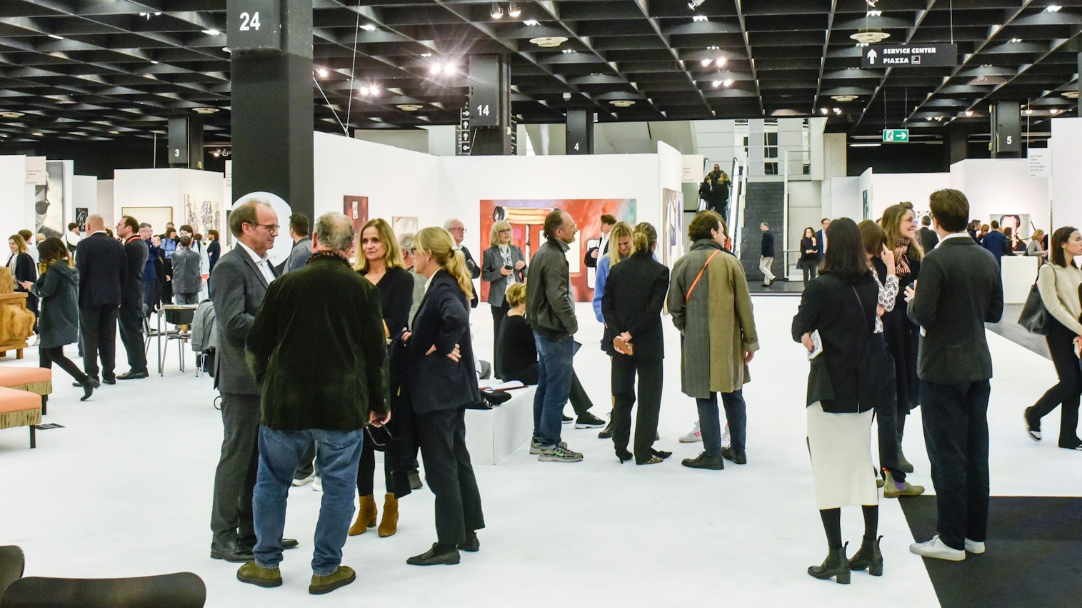 Menschen unterhalten sich in der Kölner Messehalle.