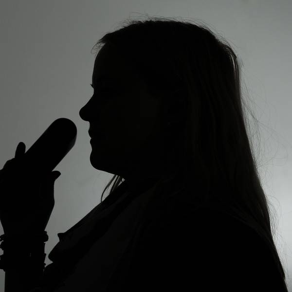 Eine Frau hält einen Telefonhörer (gestellte Aufnahme, Symbolbild).