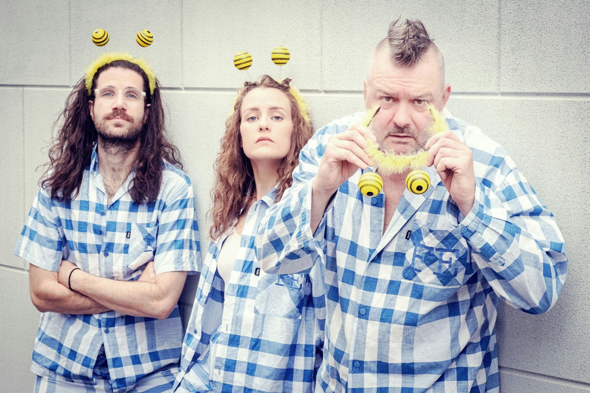 Jannis Küpfer, Elin Bell und Martin Bechler stehen nebeneinander vor einer Mauer.