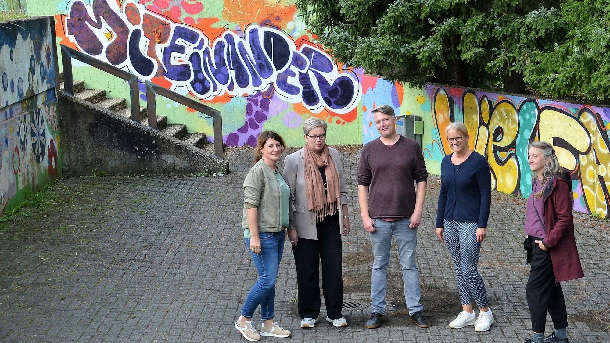 Die Graffiti auf dem Hof der Waldbröler Roseggerschule sind in einer früheren Kooperation mit den Respect Coaches und dem Kölner Graffiti-Künstler Semor entstanden. Auf Solidarität hoffen nun (von links) Heike Braun (Internationaler Bund), Christa Sostmann (Realschule), Tim Schmidt (Respect Coach), Kerstin Claus-Ising (Roseggerschule) und Kathrin Rzany (Internationaler Bund).