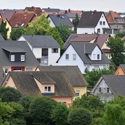 Viele Einfamilienhäuser sind zu sehen, drumherum Baumgrün.
