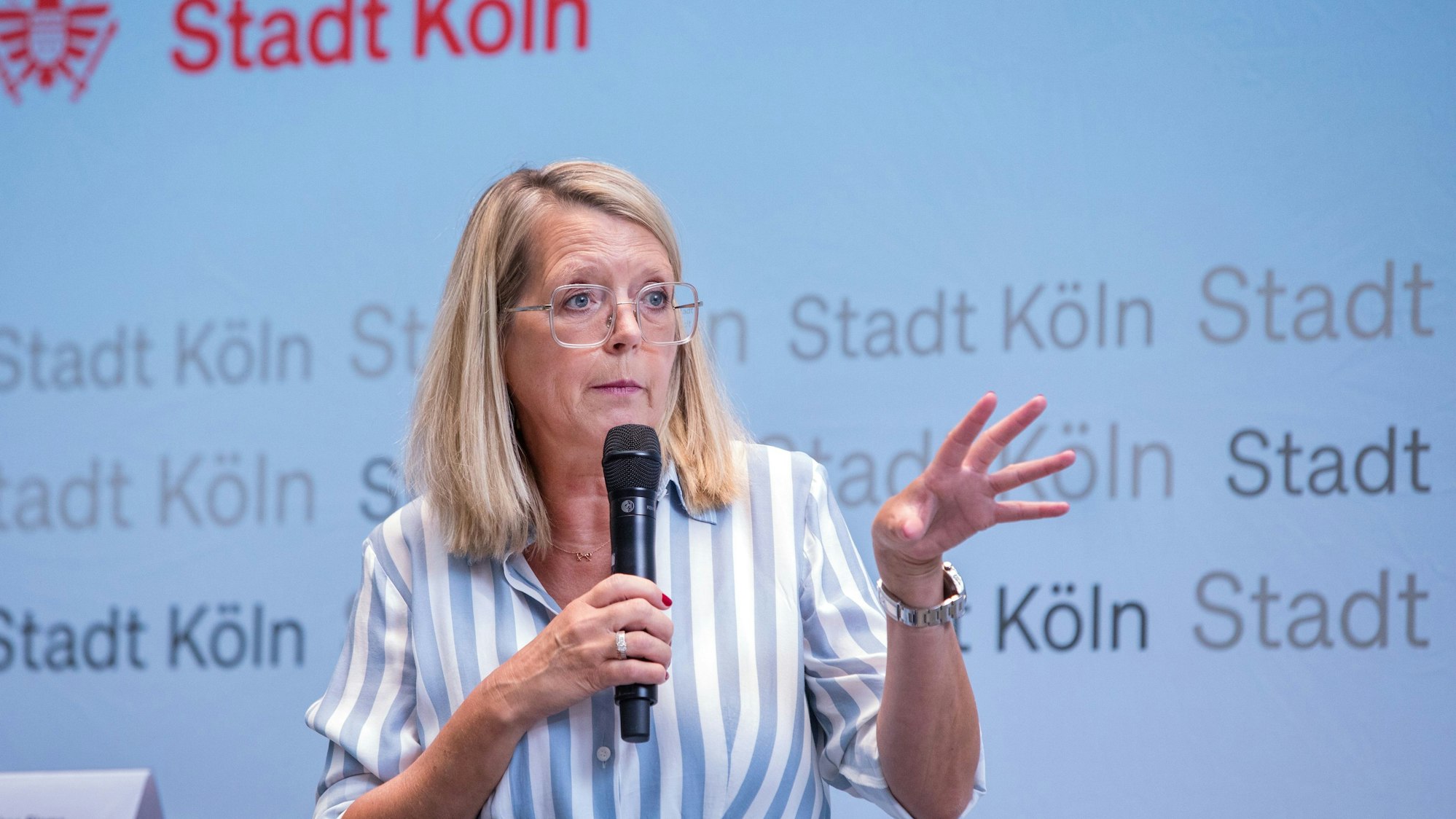 Stadtdirektorin Andrea Blome hält ein Mikrofon in der Hand.