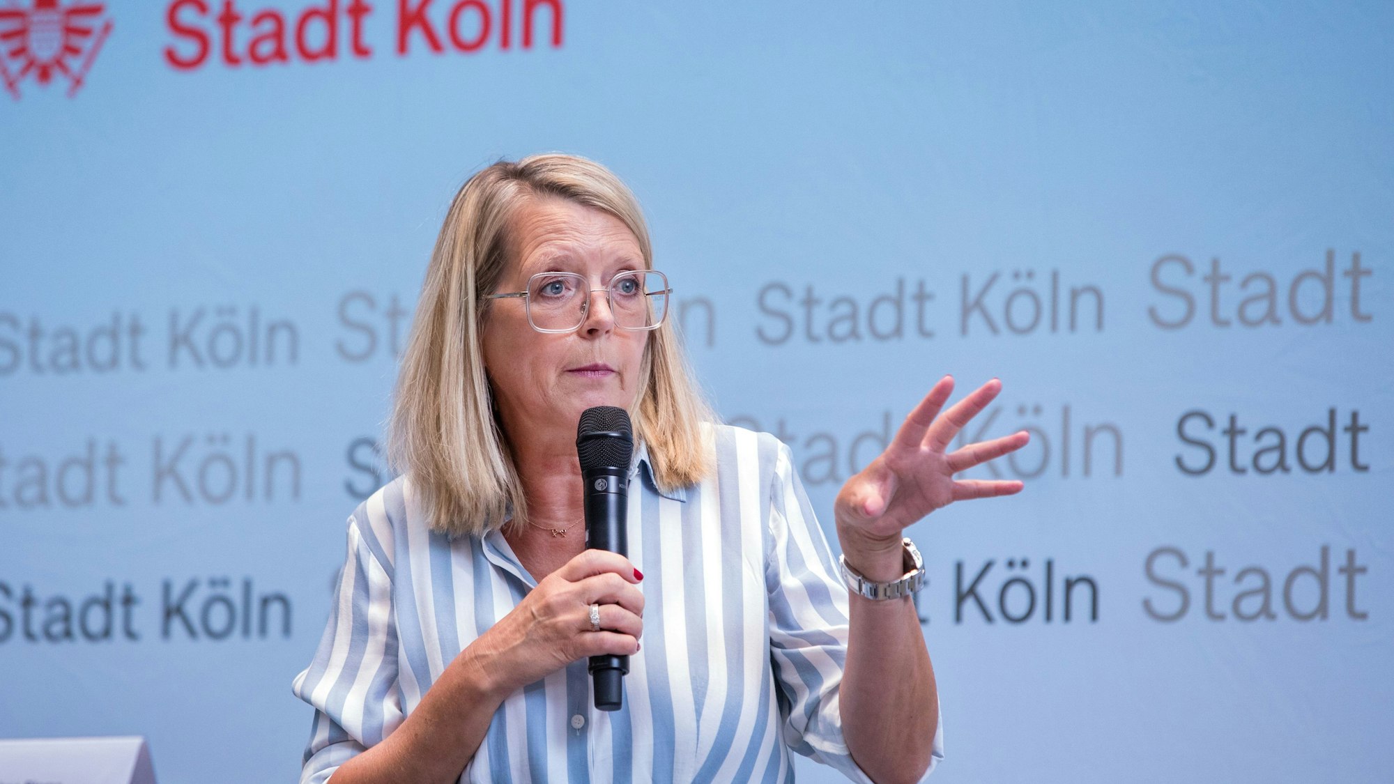 Stadtdirektorin Andrea Blome hält ein Mikrofon in der Hand.