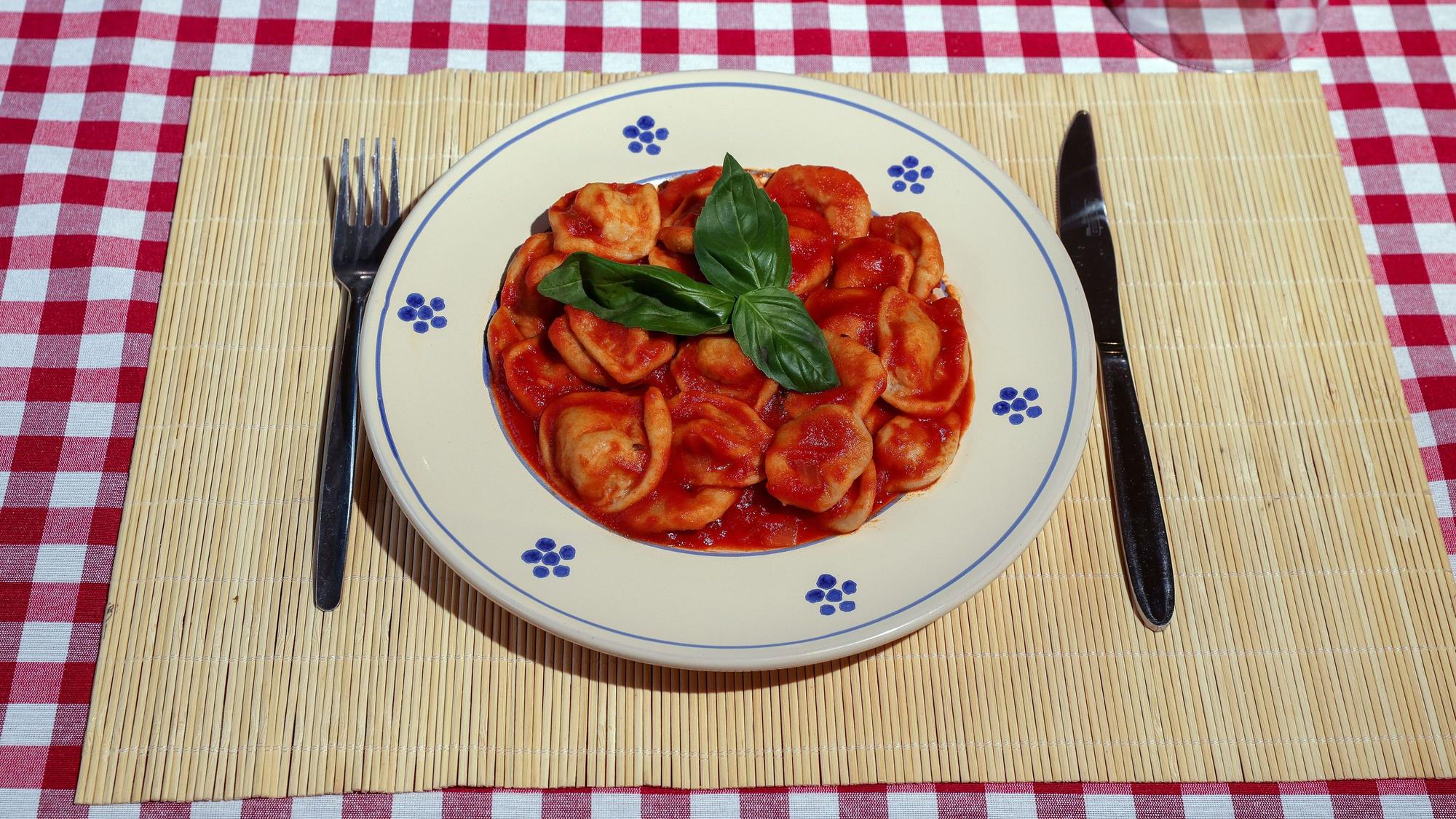 Ein Teller Orechiette-Nudeln mit Tomate und Ricotta.