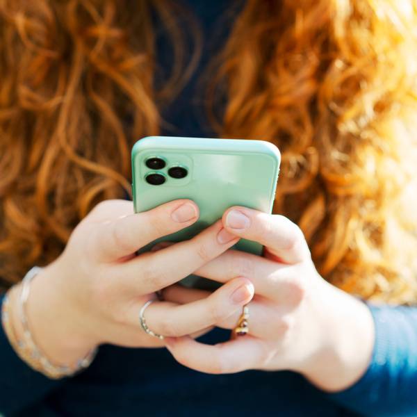 Junge Frau spielt mit ihrem Handy.
Getty Images / Tim Robberts
