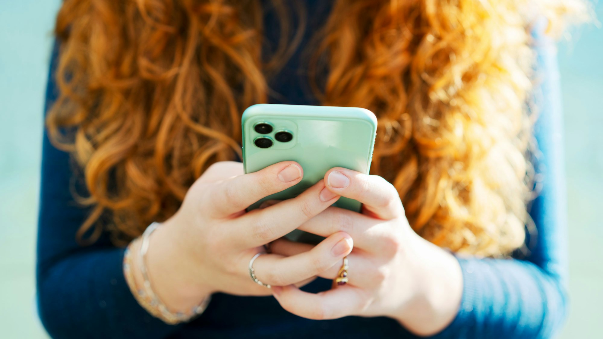 Junge Frau spielt mit ihrem Handy.
Getty Images / Tim Robberts