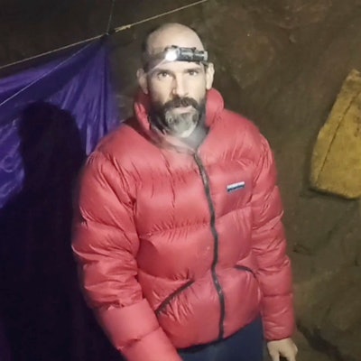 In einer Videobotschaft aus der Höhle drückte Mark Dickey seine Dankbarkeit gegenüber der Gemeinschaft der Höhlenforscher und der türkischen Regierung aus. Nur seine Stirnlampe spendet etwas Licht.