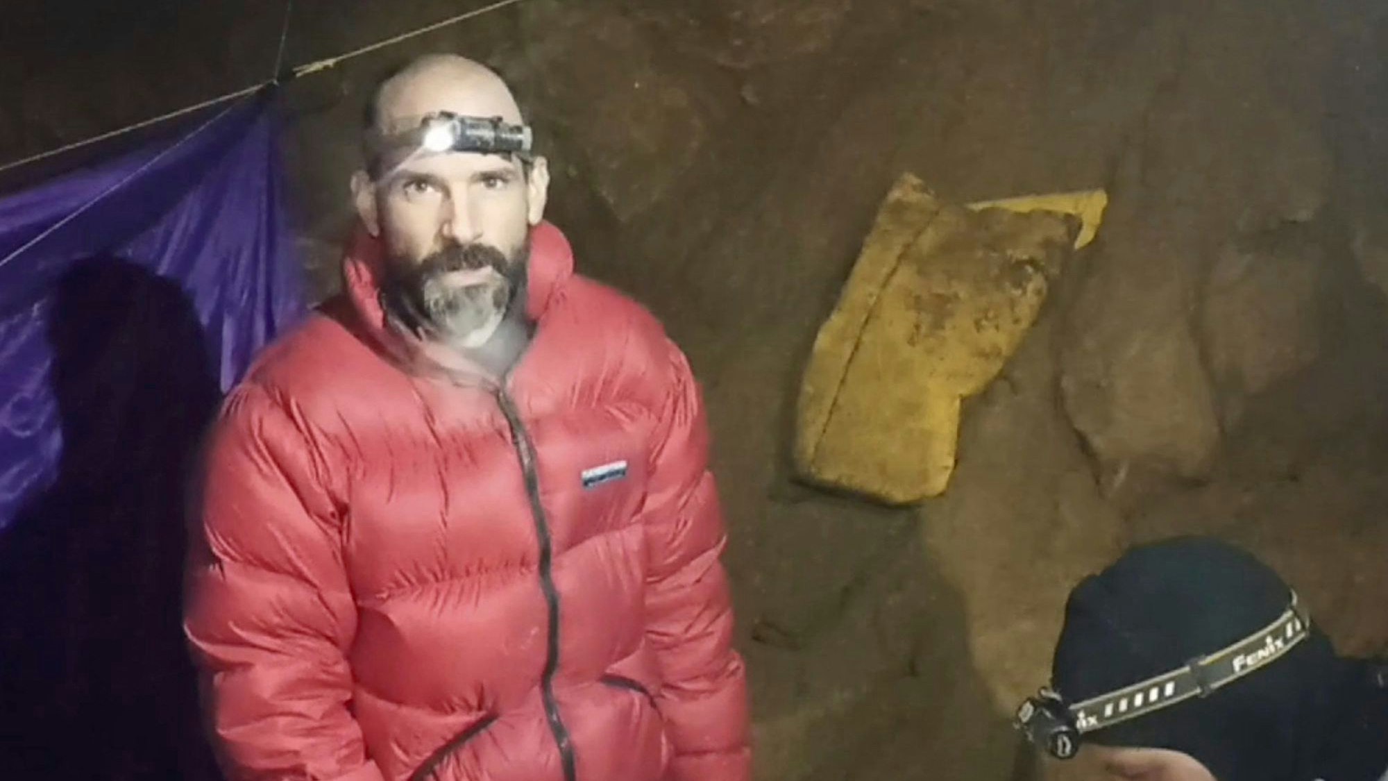 In einer Videobotschaft aus der Höhle drückte Mark Dickey seine Dankbarkeit gegenüber der Gemeinschaft der Höhlenforscher und der türkischen Regierung aus. Nur seine Stirnlampe spendet etwas Licht.