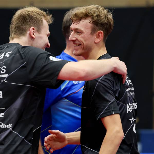 Tischtennis-Spieler Benedikt Duda umarmt seinen Mannschaftskollegen Adrien Rassenfosse.