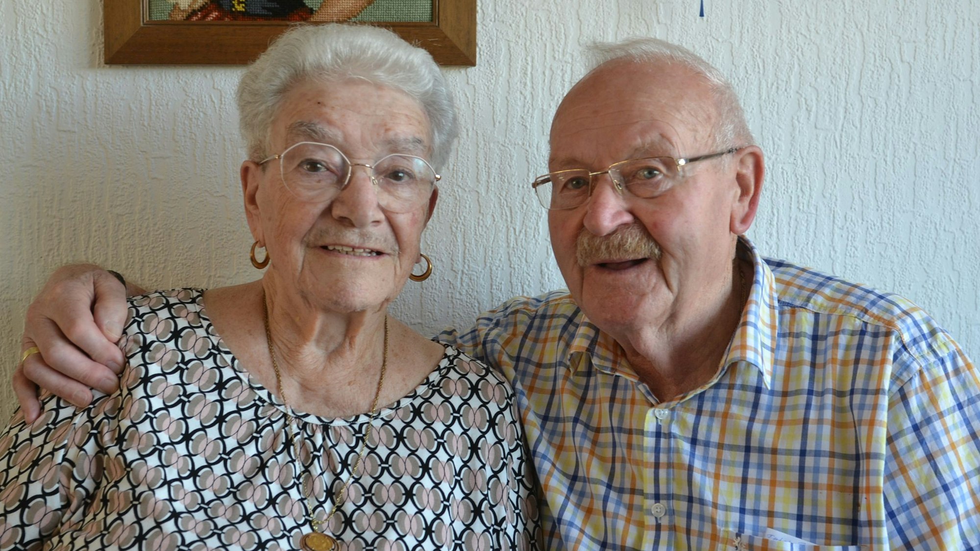 Helmut Rick hat seinen Arm um die Schultern seiner Frau gelegt.