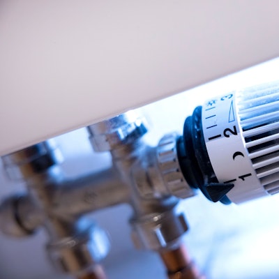 Ein Thermostat an der Heizung in einer Wohnung steht auf der Stufe 1, daneben sind ein Mond und die Stufe 2 zu sehen.