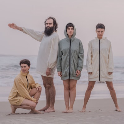 Die Band steht am Strand.