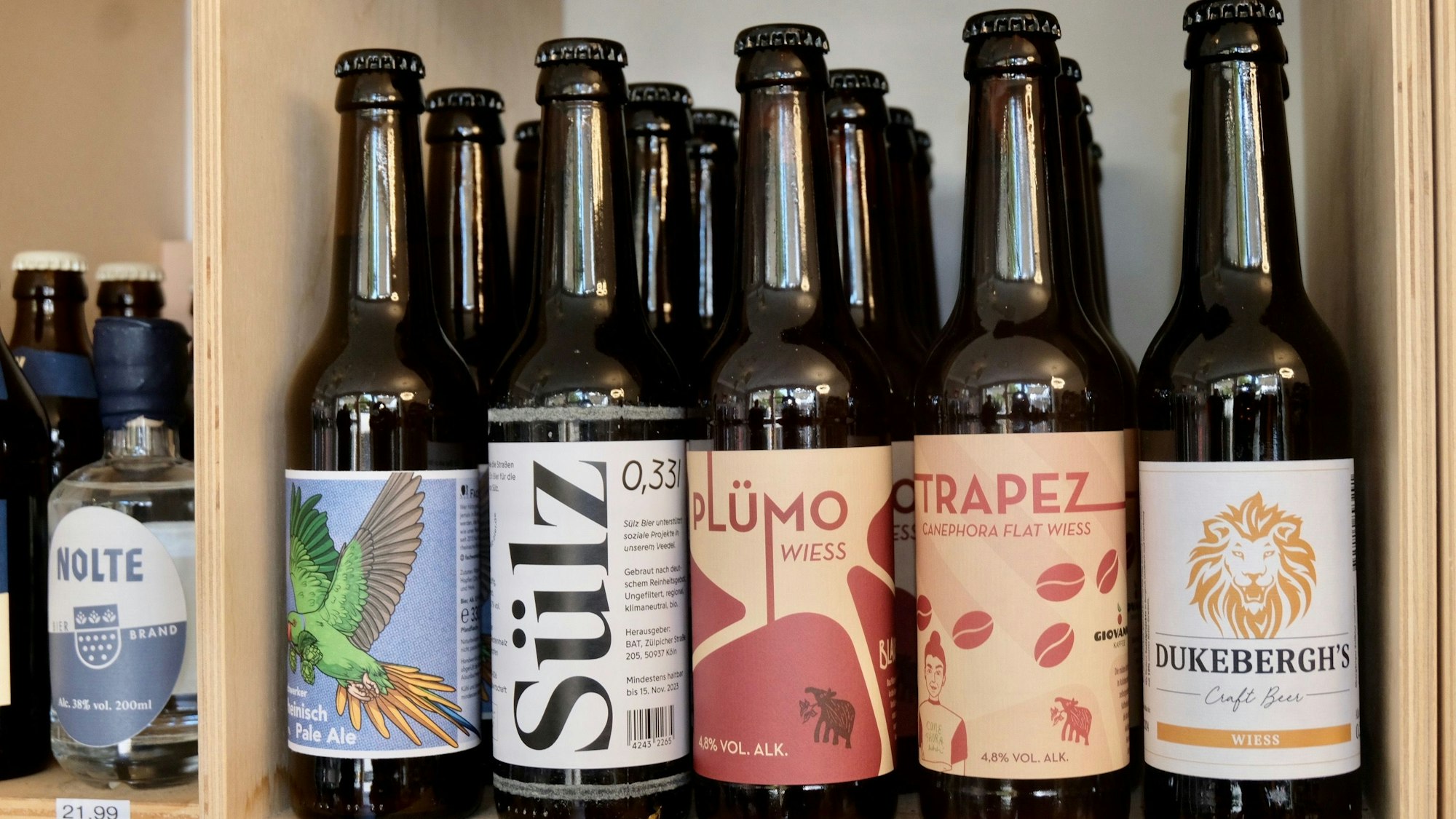 Bier-Flaschen verschiedenster Marken stehen im Regal.