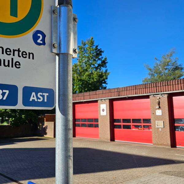 Das Bild zeigt das Feuerwehrgerätehaus und die Bushaltestelle Kirchherten Schule.