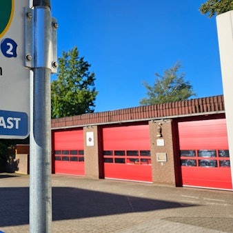 Das Bild zeigt das Feuerwehrgerätehaus und die Bushaltestelle Kirchherten Schule.