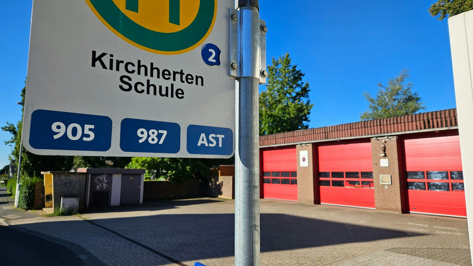 Das Bild zeigt das Feuerwehrgerätehaus und die Bushaltestelle Kirchherten Schule.