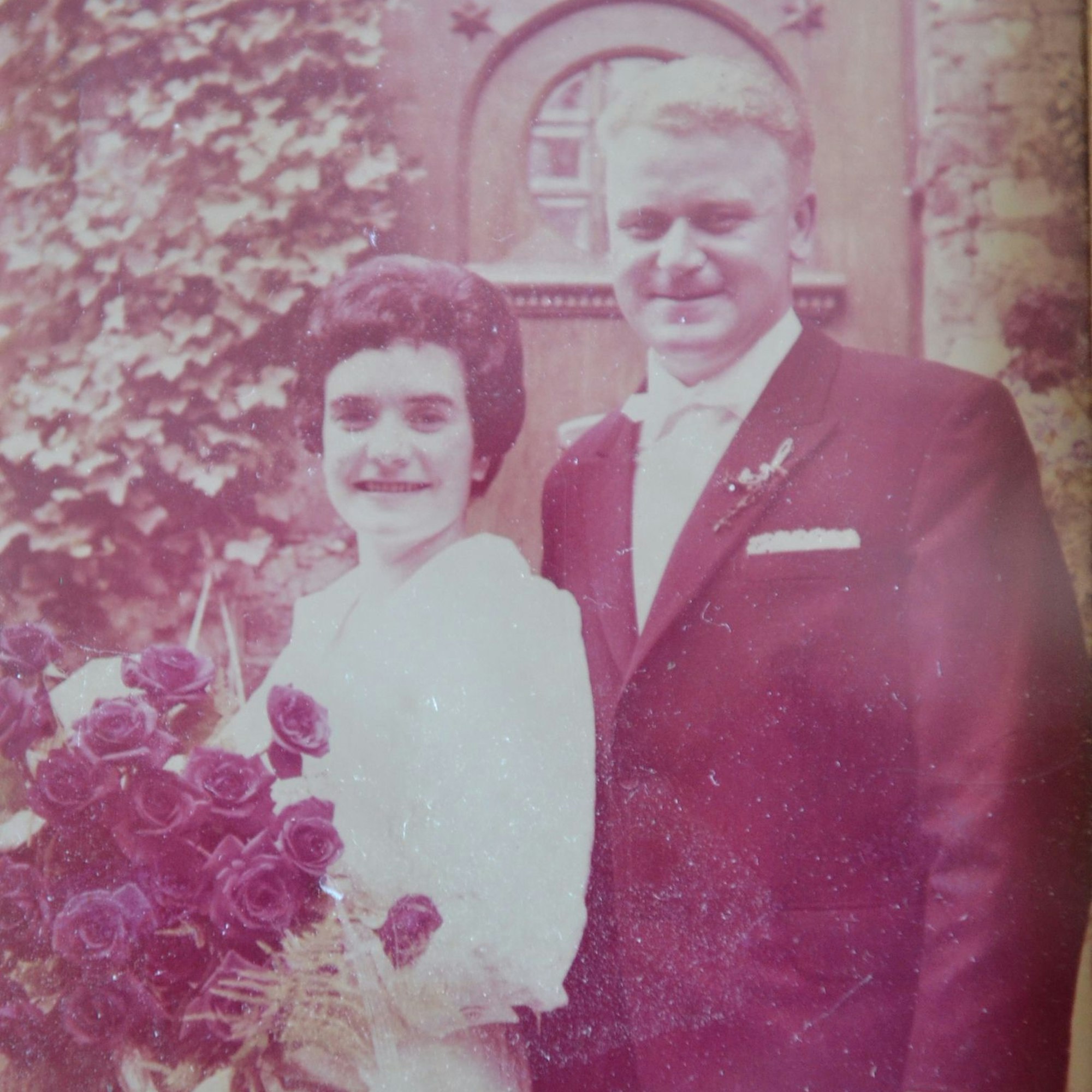 Das Hochzeitsfoto der Eheleute. Liesel Rick hält einen großen Brautstrauß mir Rosen in den Händen.