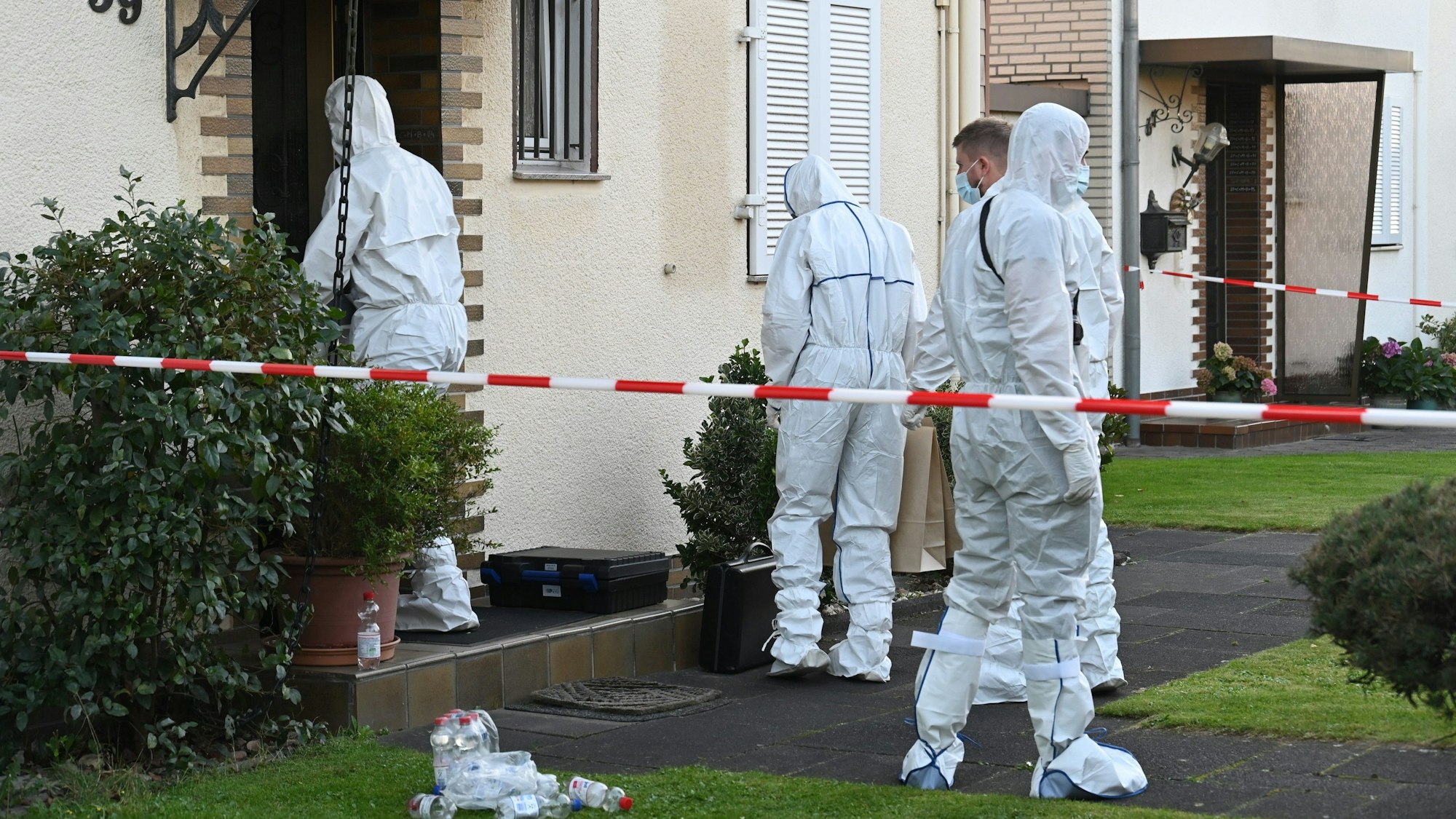 Das Bild zeigt mehrere Kripobeamte in weißen Schutzanzügen vor dem Haus des verstorbenen Rentners.