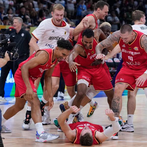 Andreas Obst liegt auf dem Boden, seine Teamkollegen feiern ihn und den Halbfinal-Sieg gegen die USA.