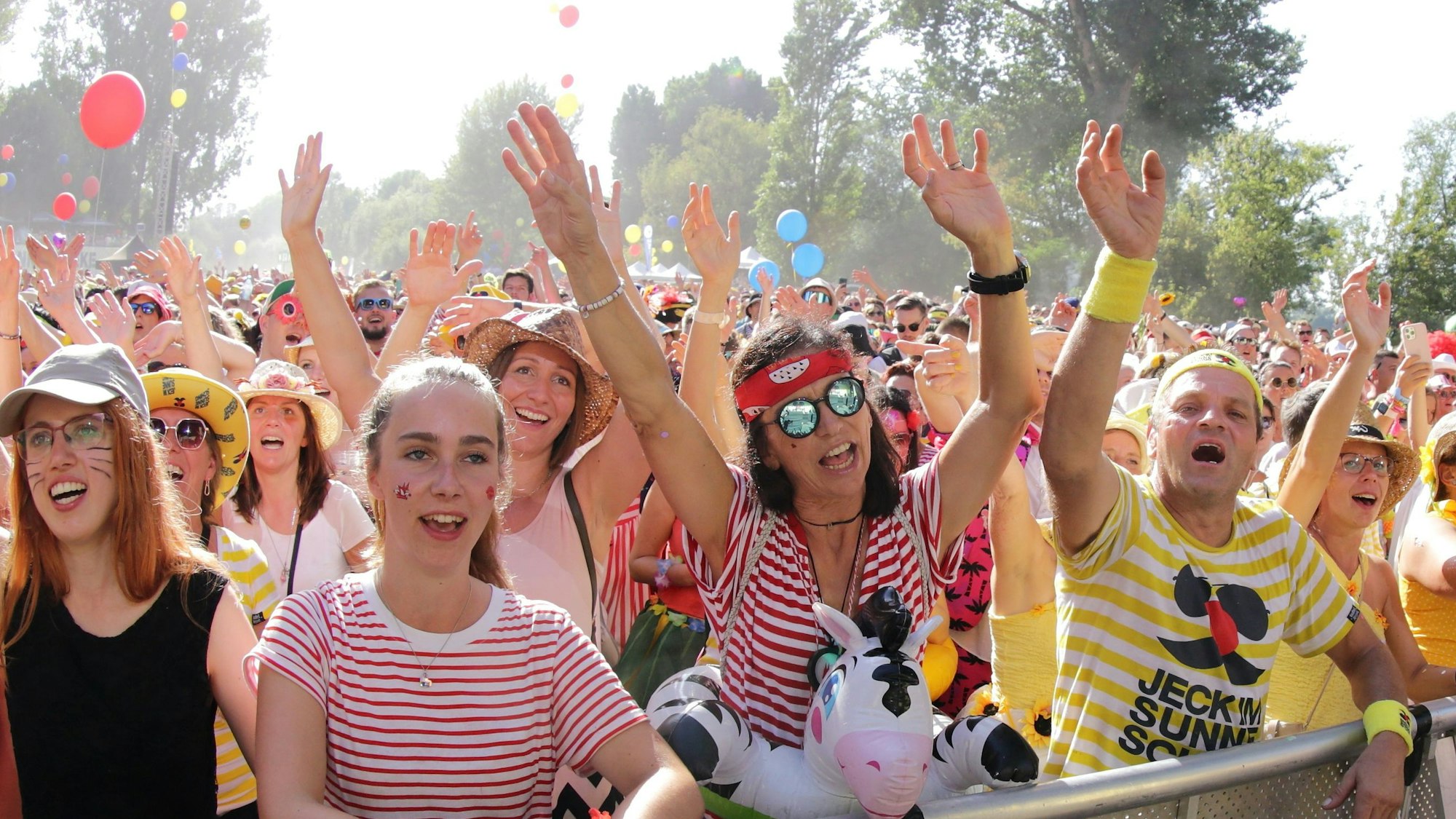 Frauen jubeln hinter der Absperrung einer Bühne.