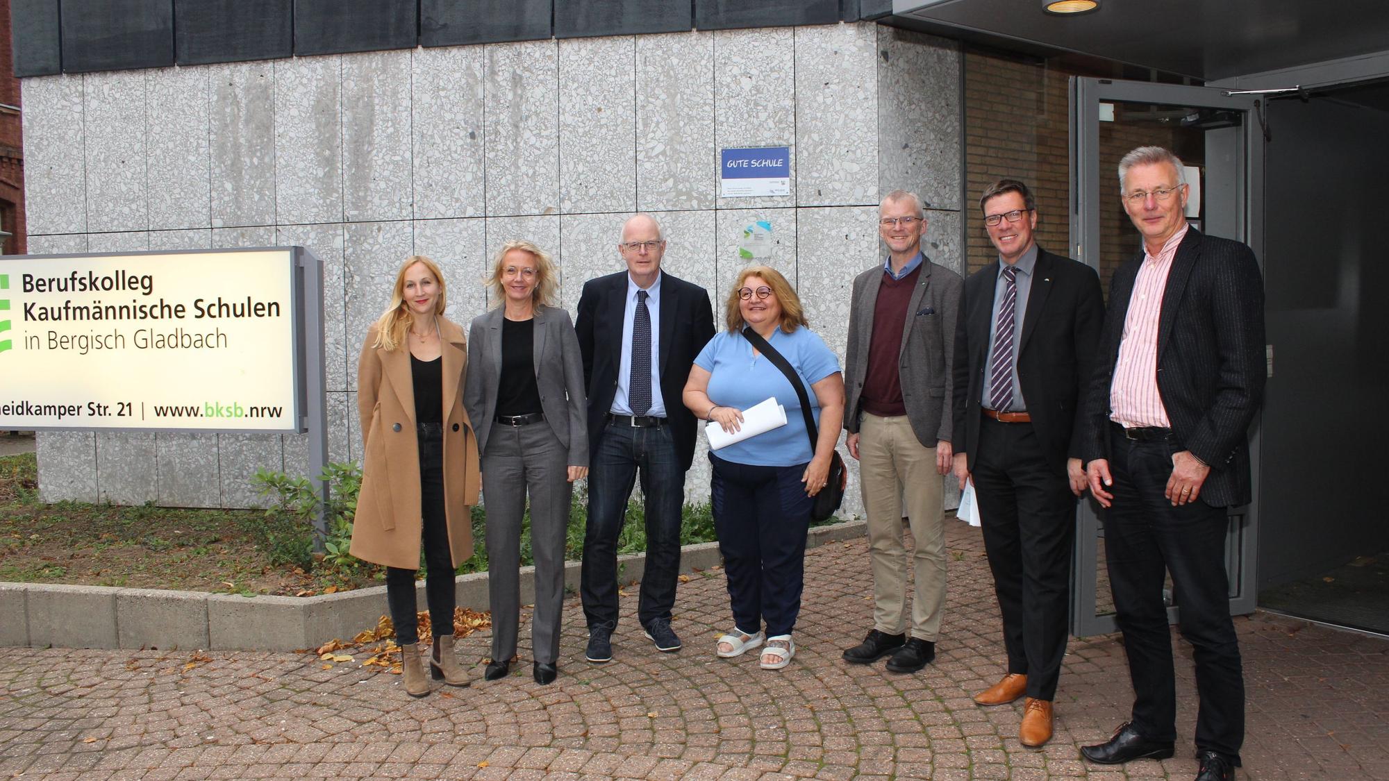 Menschen stehen vor dem Berufskolleg in Bergisch Gladbach.