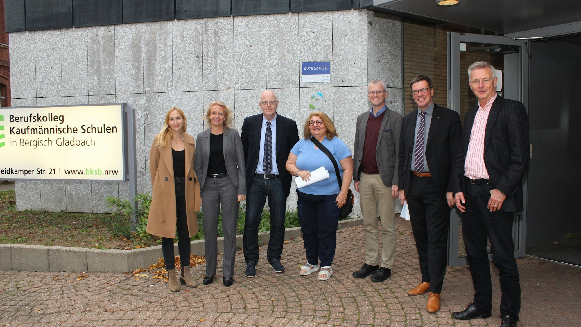 Menschen stehen vor dem Berufskolleg in Bergisch Gladbach.