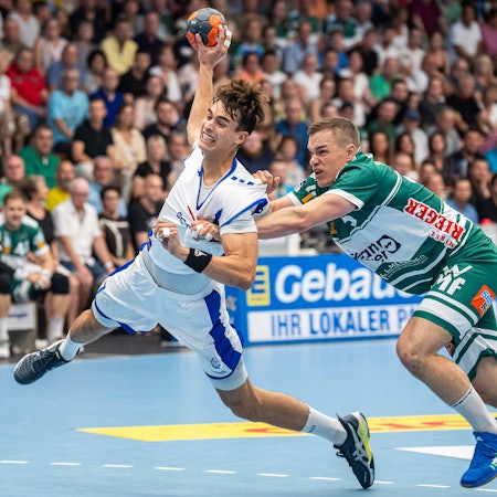 Der Gummersbacher Julian Köster lässt sich von Göppingens Vid Poteko nicht stoppen, der von hinten am Trikot des VfL-Handballers zerrt.