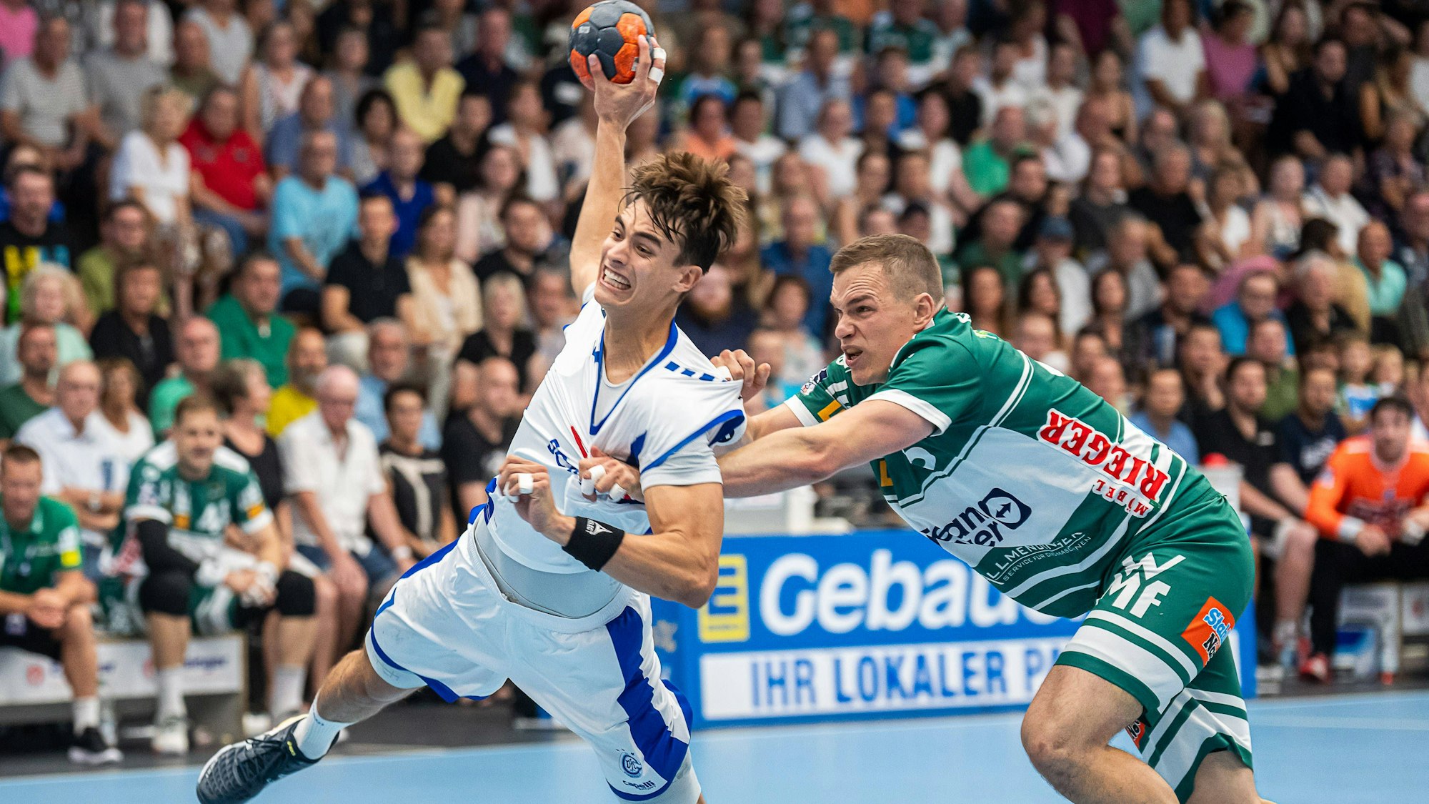 Der Gummersbacher Julian Köster lässt sich von Göppingens Vid Poteko nicht stoppen, der von hinten am Trikot des VfL-Handballers zerrt.