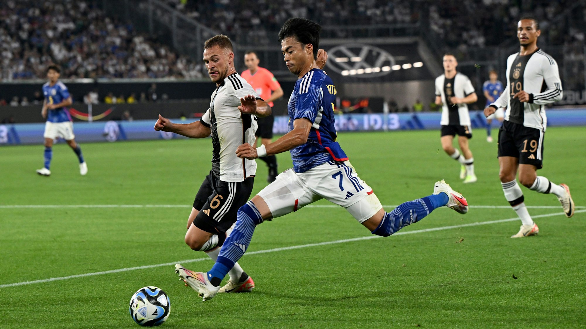Deutschlands Joshua Kimmich (l.) attackiert Japans Kaoru Mitoma.