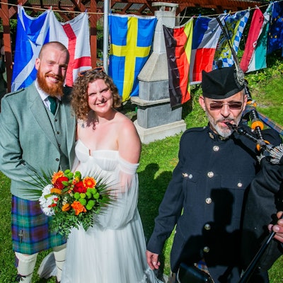 Mit Musik von Dudelsackspieler Michael Hoffmann von der Gruppe „Call of Pipes“ aus Waldbröl feiert das schottische Paar Nils und Anna Fritsch am Samstagnachmittag in Wiehl-Merkausen und im Kreise der weitverzweigten Familie noch einmal Hochzeit. Hier steht das Paar vor den Fahnen der beteiligten Nationen.