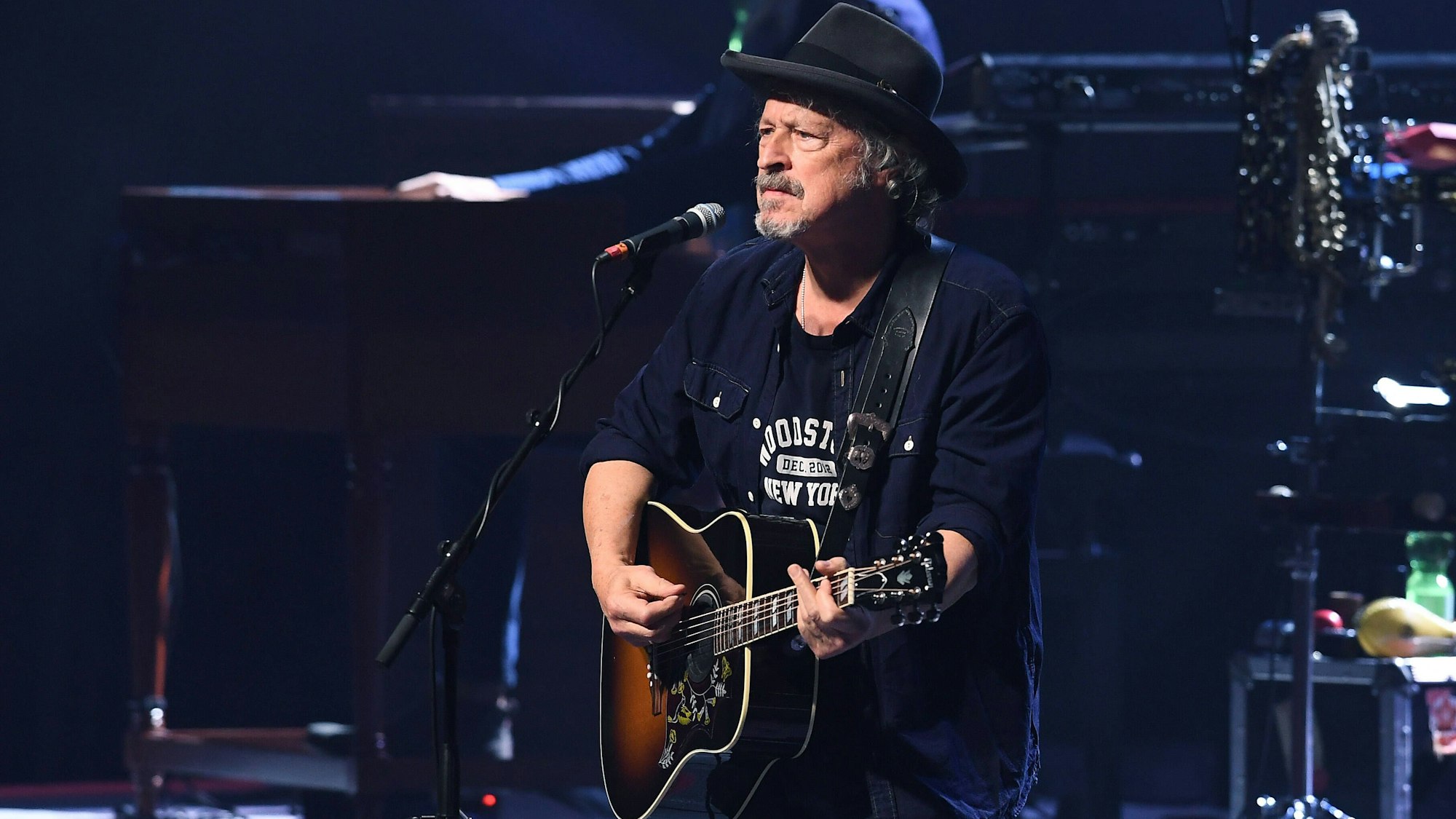 Wolfgang Niedecken steht auf der Bühne und spielt Gitarre.