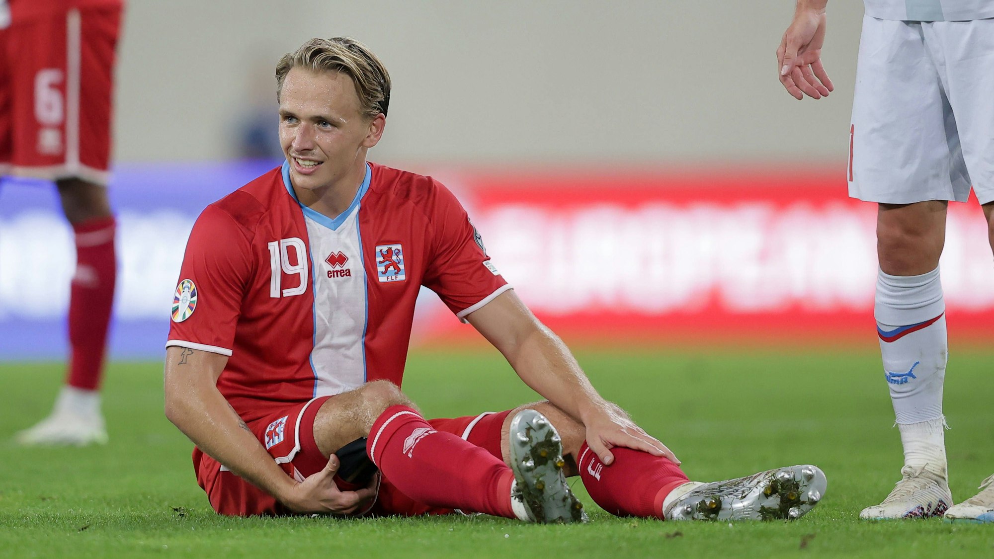 Luxemburgs Nationalspieler Mathias Olesen fasst sich an den rechten Oberschenkel.