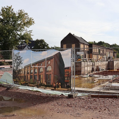 Eine Baustelle hinter einem Bauzaun ist zu sehen.