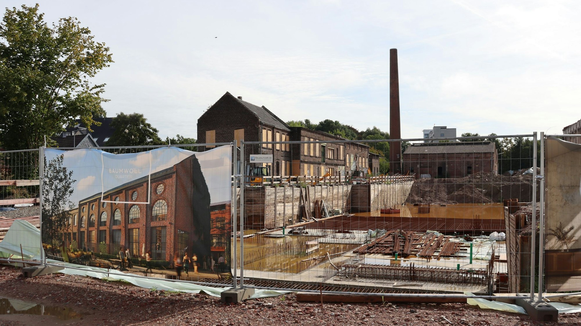 Eine Baustelle hinter einem Bauzaun ist zu sehen.