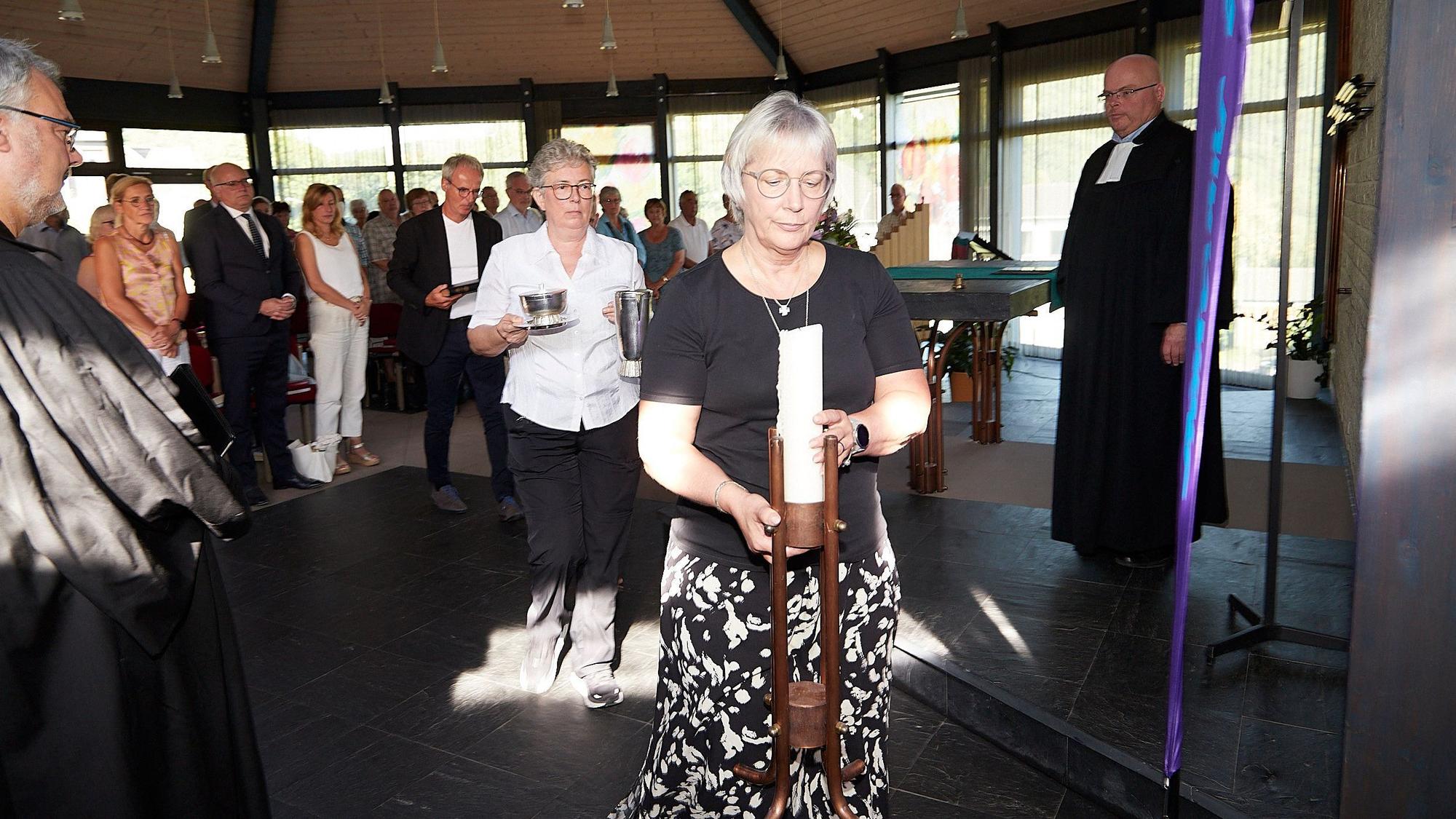 Die Presbyter tragen Gottesdienstutensilien wie Kerze oder Gefäße in die Sakristei. Vorne Gabriele Leufgen, dahinter Brigitte Weber und Roland Reddelien