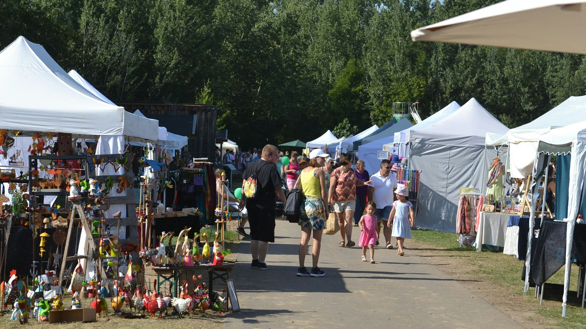 An beiden Seiten eines Wegs stehen Ausstellungspavillons, dazwischen sind Besucher des Zülpicher Herbstmarktes zu sehen.