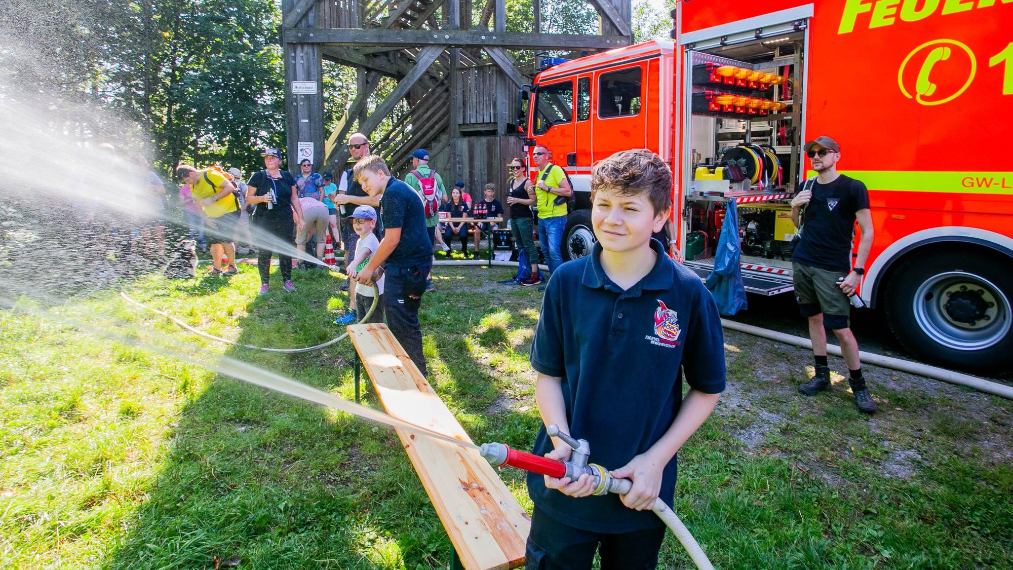 Mitglieder der Jugendfeuer Bergneustadt spritzen mit Wasser