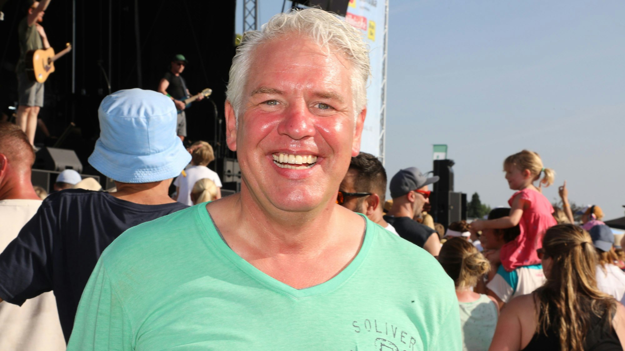 Odenthals Bürgermeister Robert Lennerts steht beim Rheinbrand-Festival vor der Bühne und strahlt.