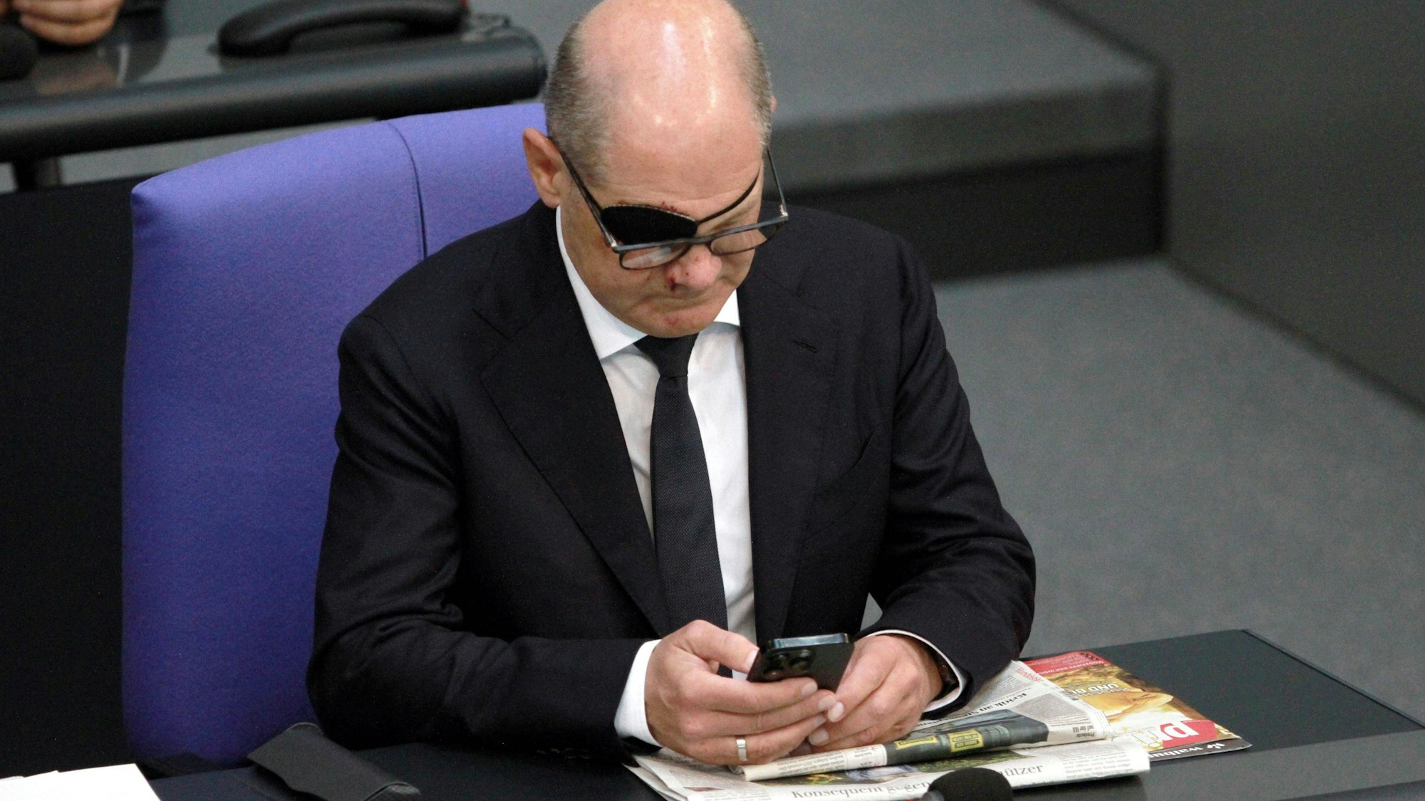 Bundeskanzler Olaf Scholz mit Handy im Bundestag. Den polnischen PiS-Vorsitzenden Jaroslaw Kaczynski braucht der SPD-Politiker einem Wahlwerbespot der polnischen Partei zufolge gar nicht erst anzurufen. (Archivbild)