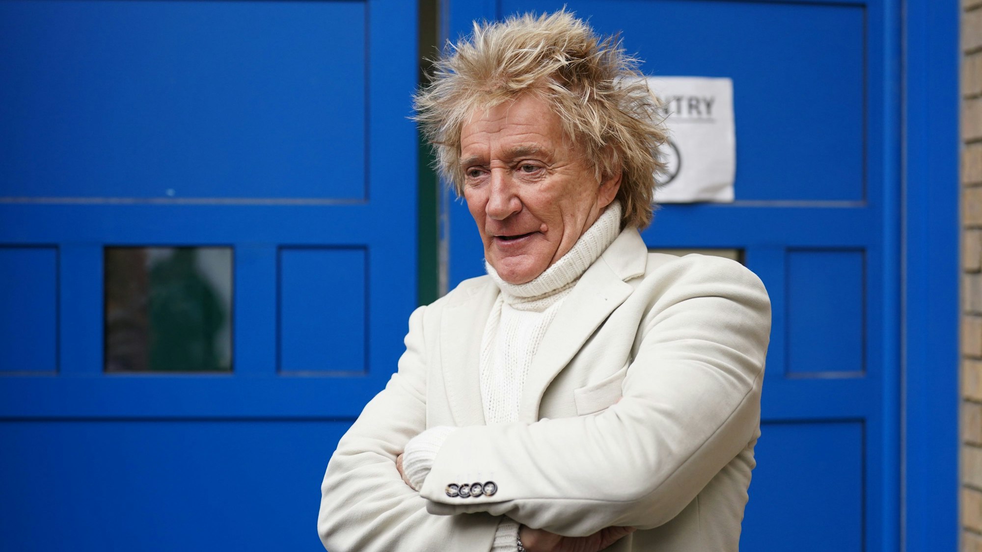 Sir Rod Stewart, Sänger aus Großbritannien, steht vor einer blauen Tür.