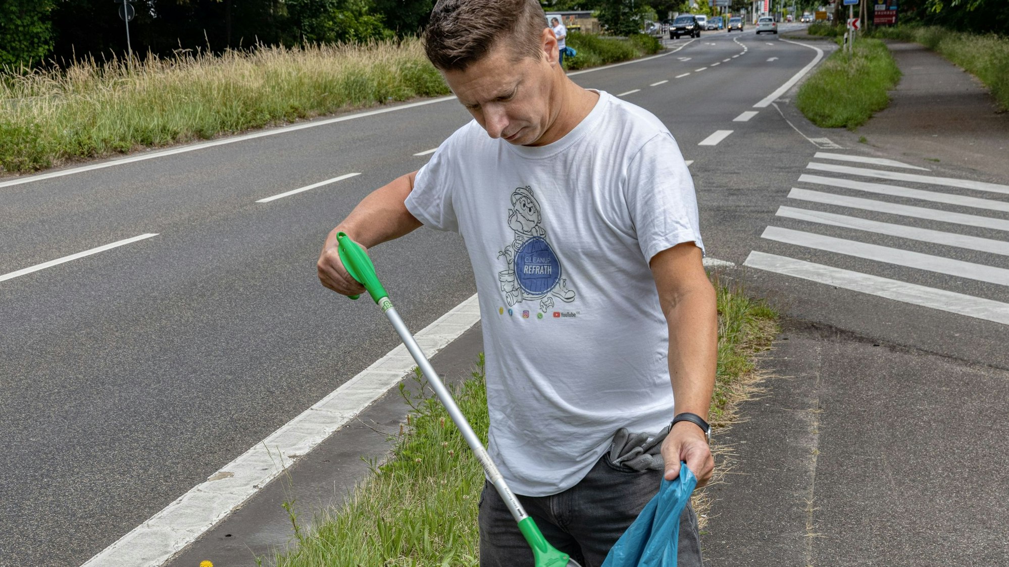 Elmar Zimmermann platziert mit einem Müllgreifer ein Fundstück im Müllsack.